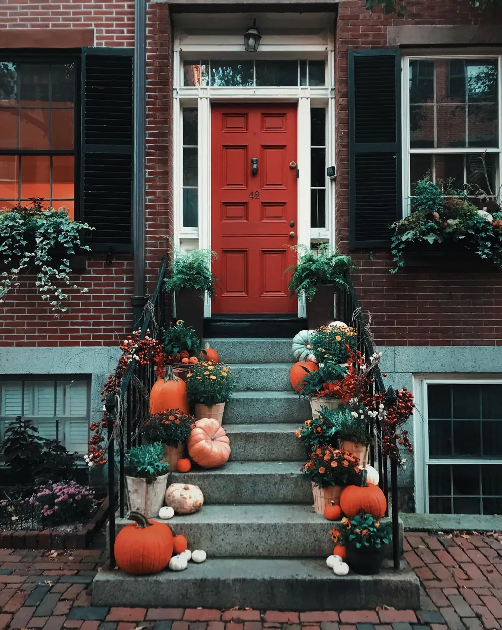 Brick steps styled with rust and yellow mums, pumpkins and ornamental kale